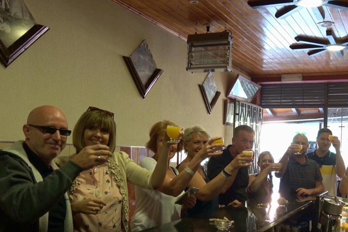 grupė žmonių, geriančių vyną bare