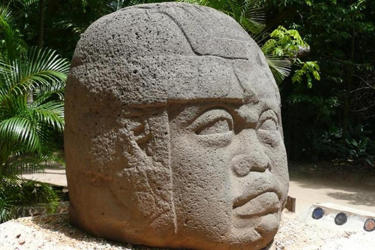 a stone statue of a head sitting on a table
