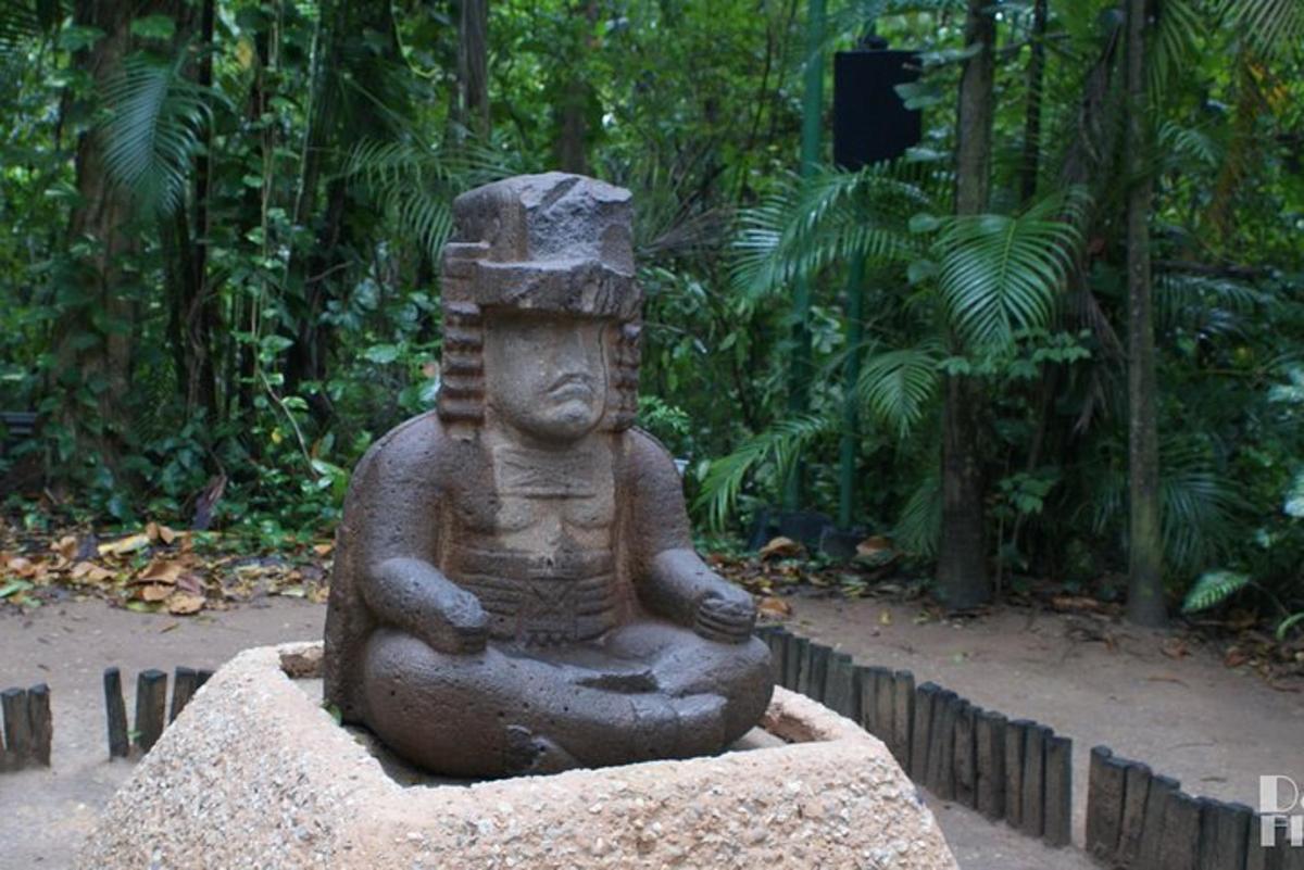 a statue sitting on top of a rock