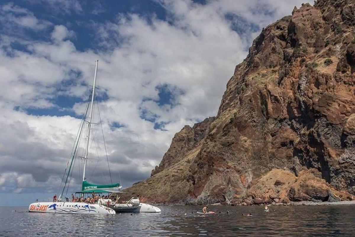 a boat in the water next to a mountain