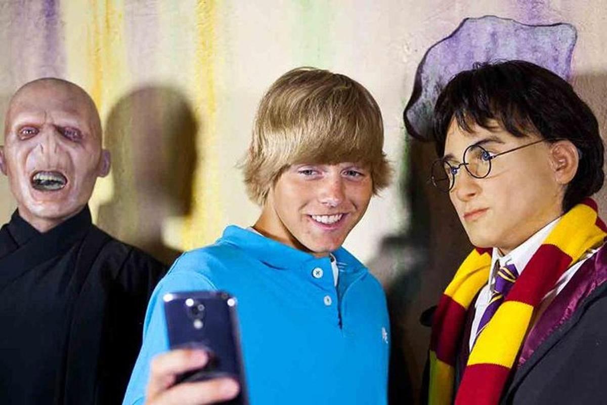 um homem tirando uma foto de duas pessoas com um celular