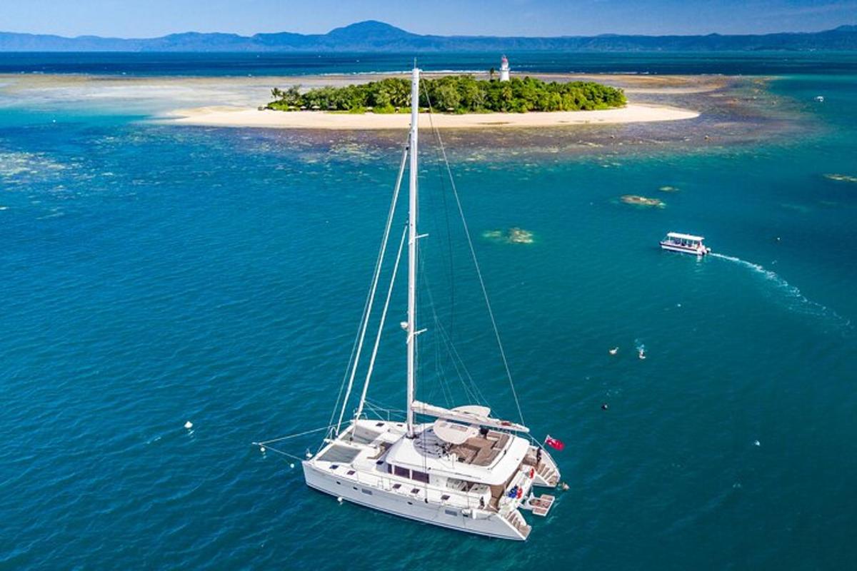 a white boat in the water with an island