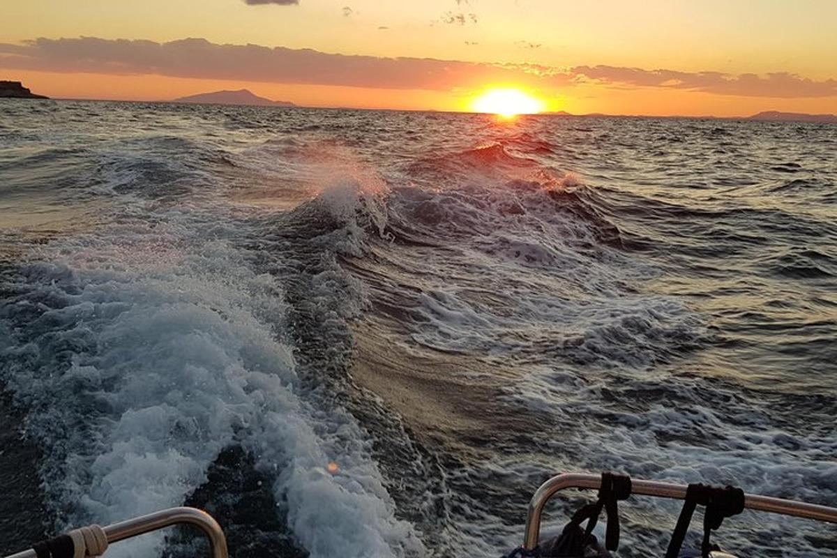loď v oceánu se západem slunce v pozadí