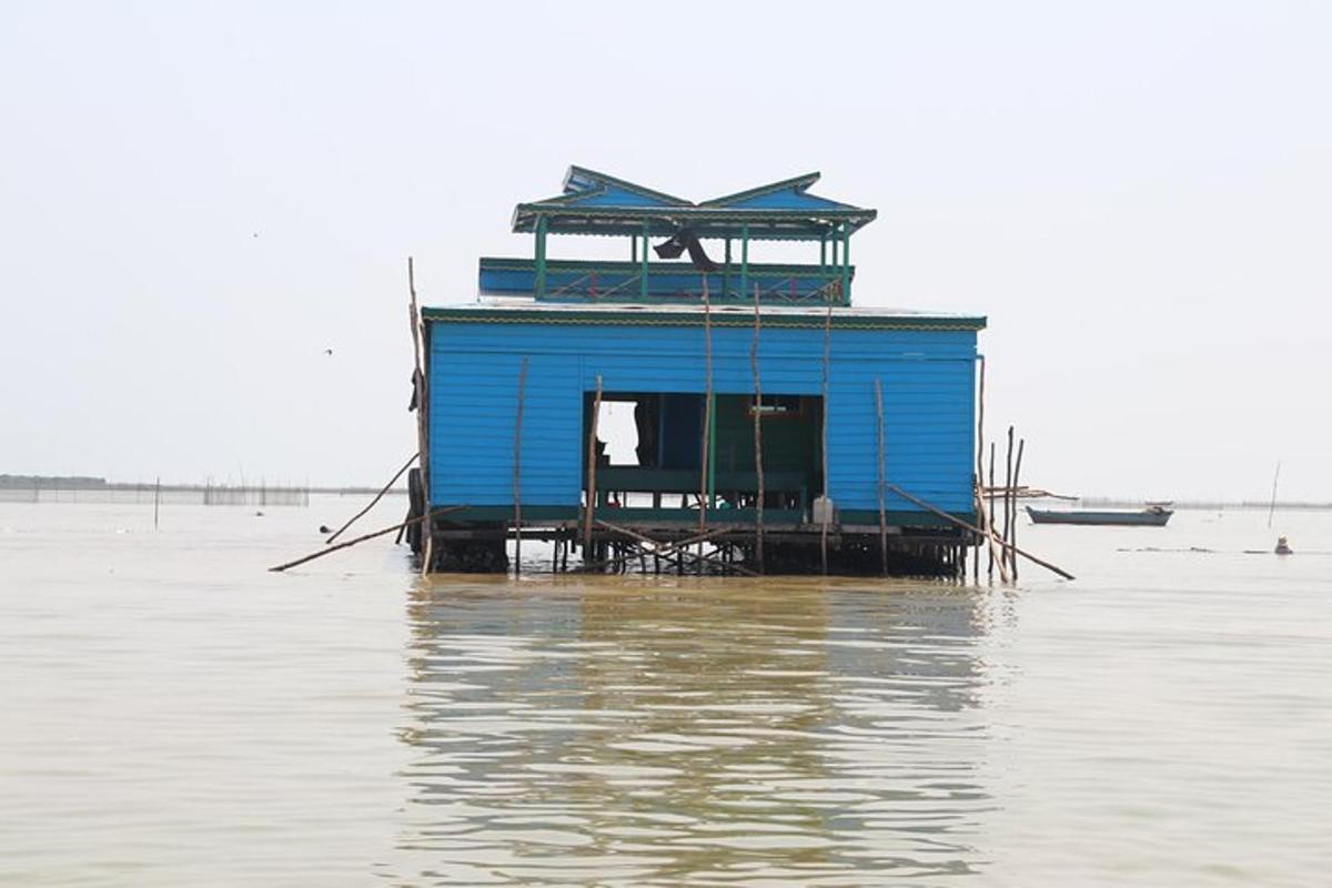 uma casa azul sentada sobre a água