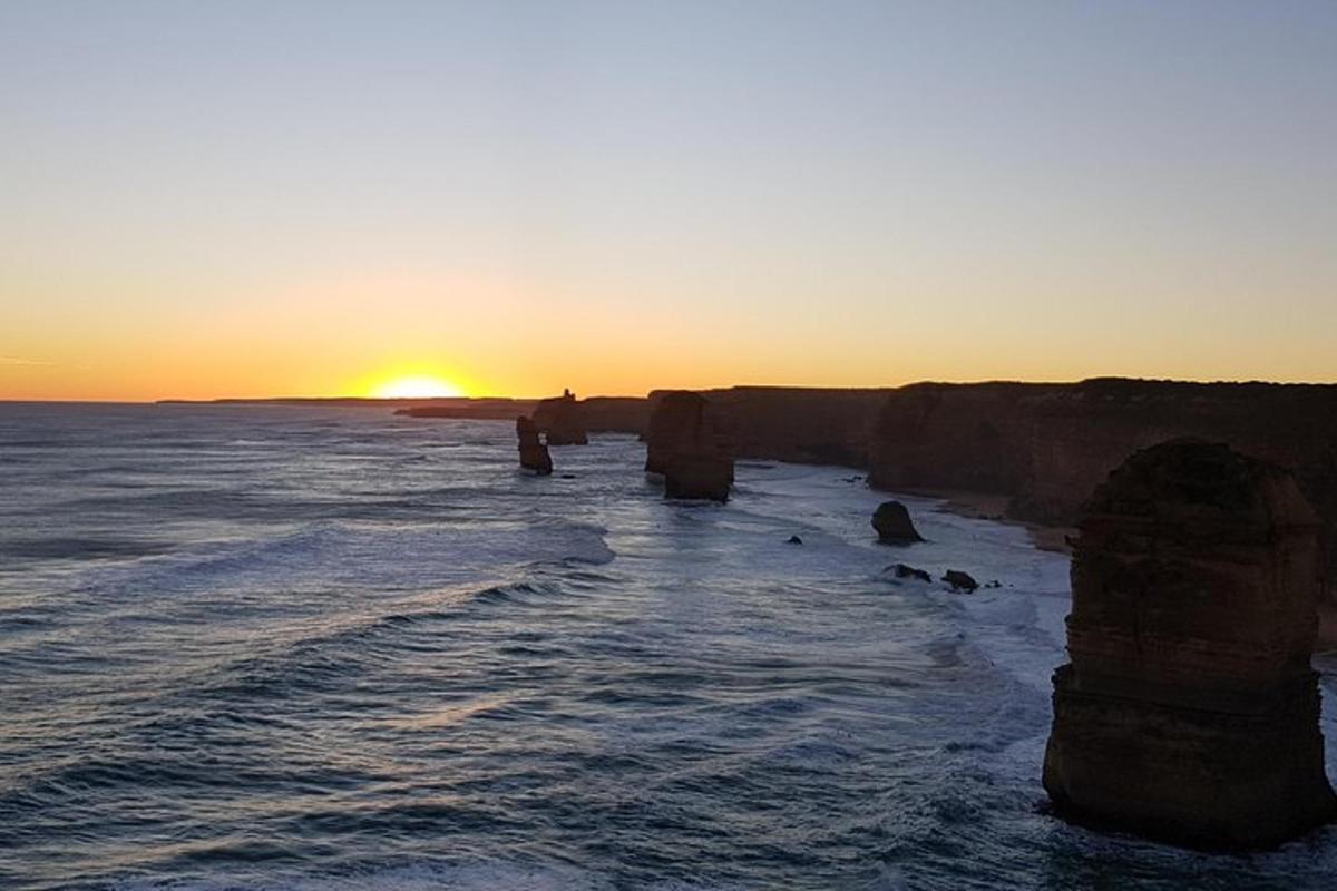 un grup de roques a l'oceà a la posta de sol