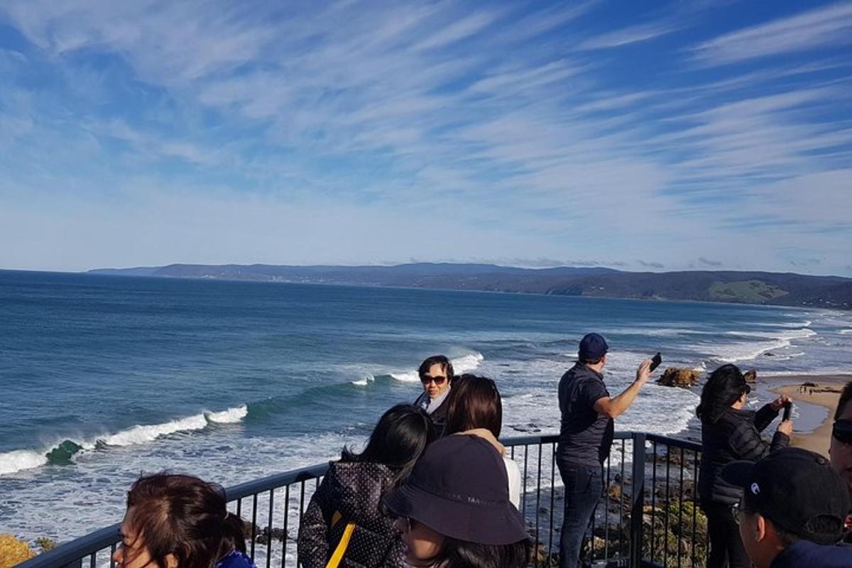 un grup de persones fent fotos de l'oceà