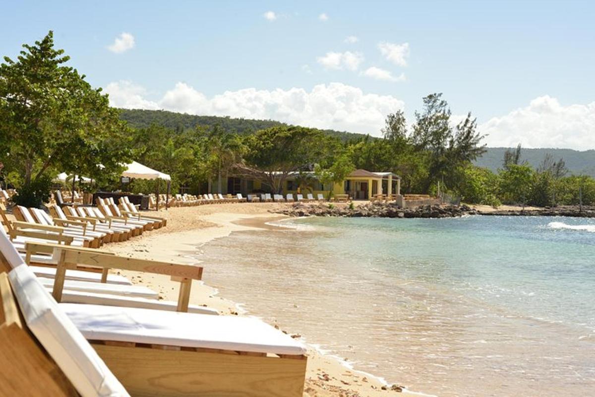 a beach with lounge chairs and the ocean
