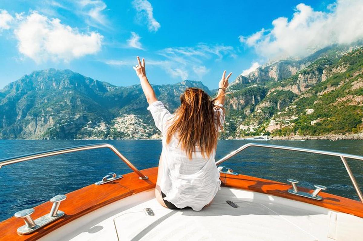 una donna seduta sulla prua di una barca