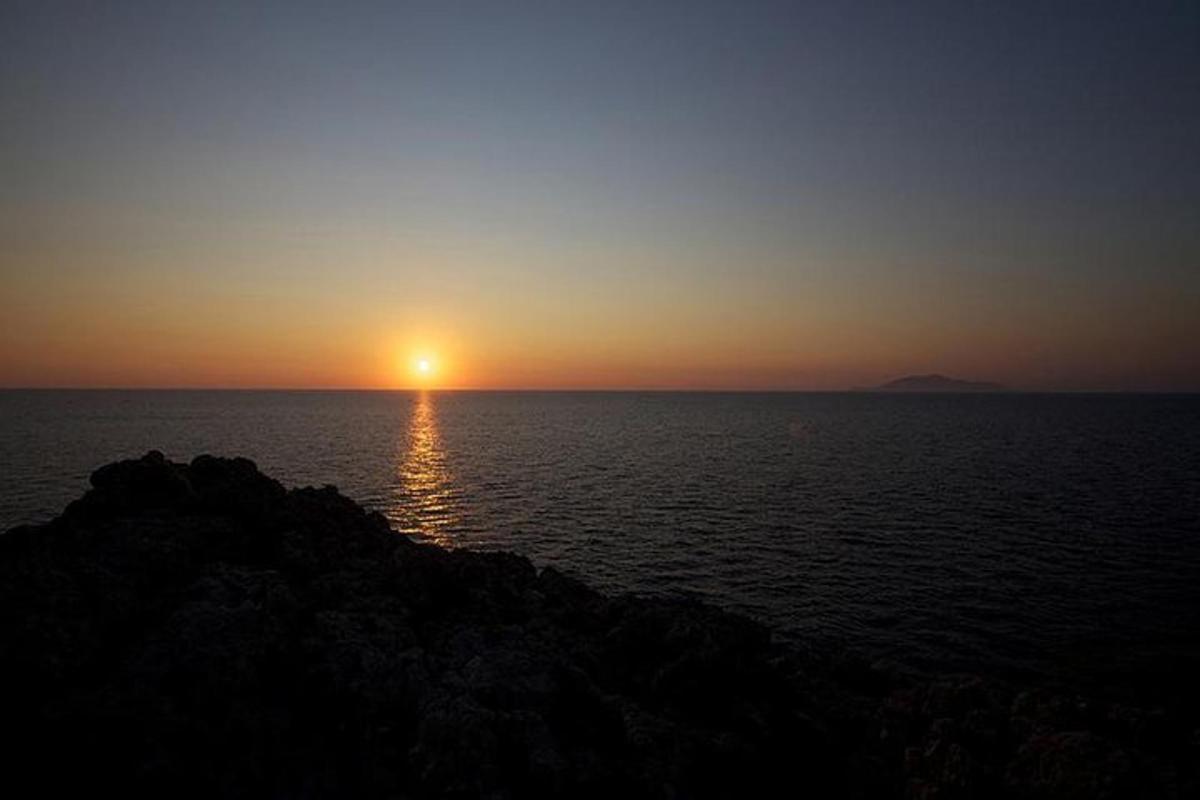 západ slunce nad oceánem se zapadajícím sluncem