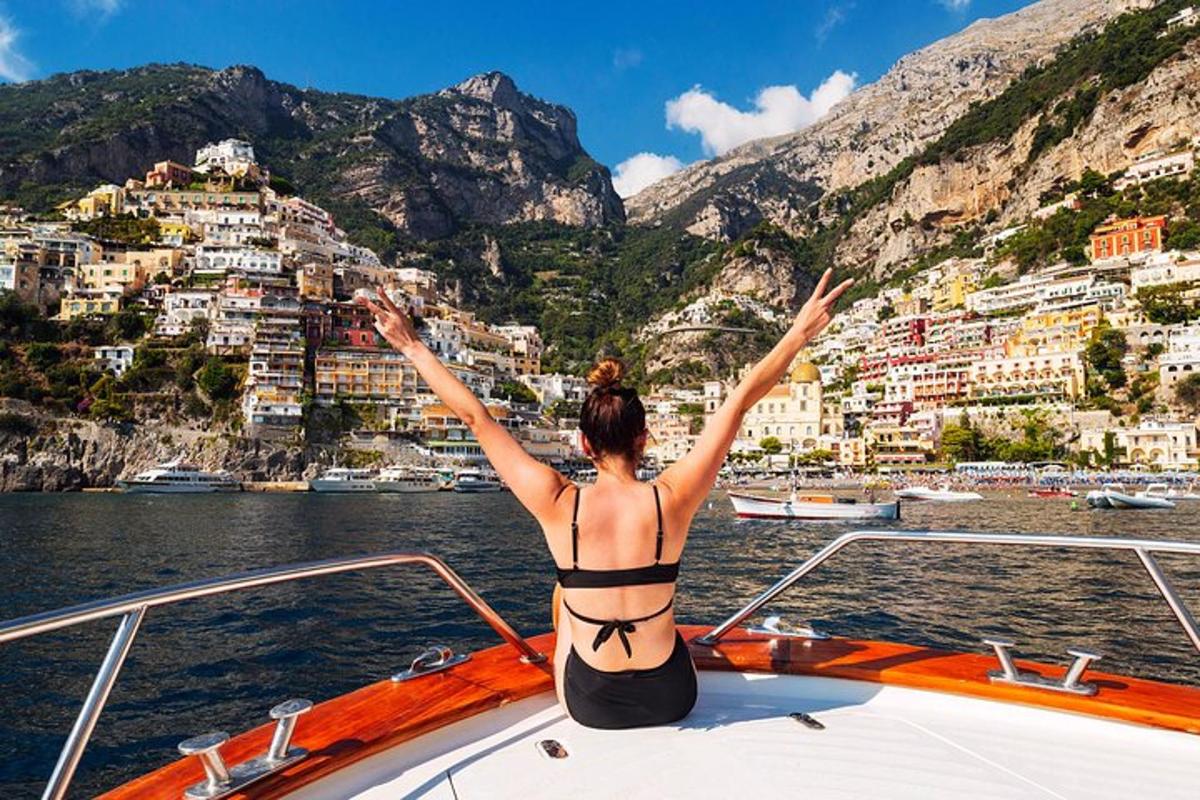 una donna in bikini seduta sulla parte anteriore di una barca