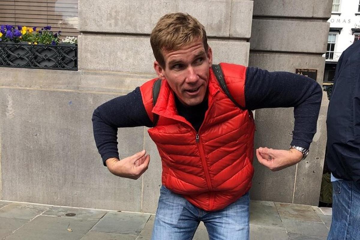a man wearing a vest with his arms out