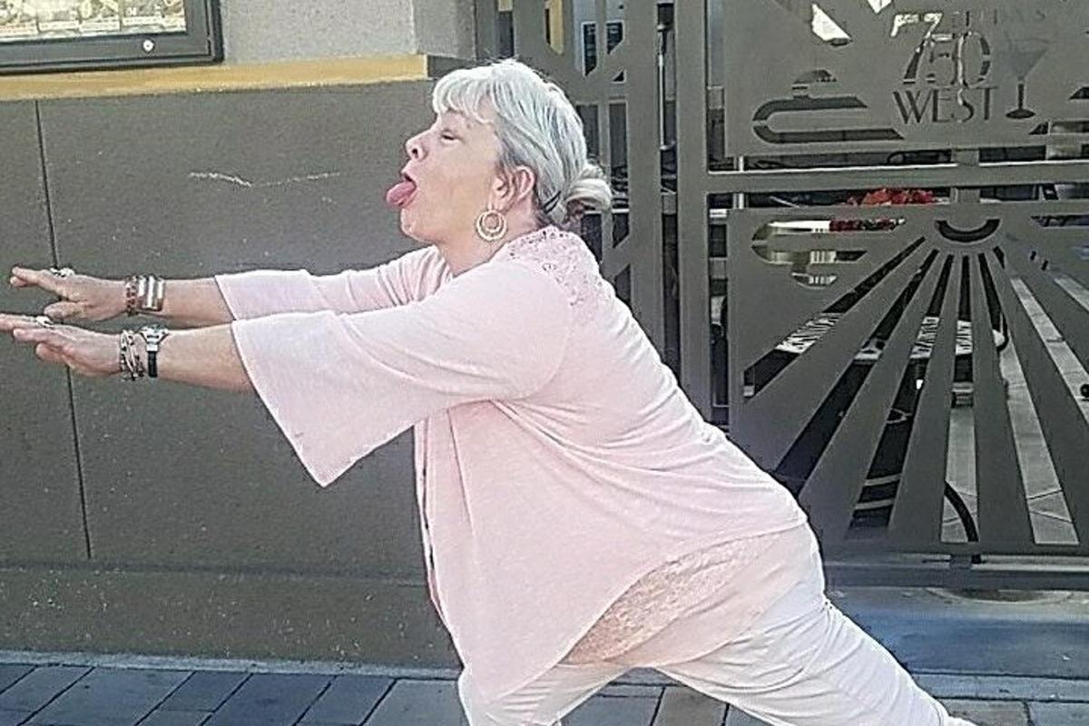 Starší žena tančí před budovou