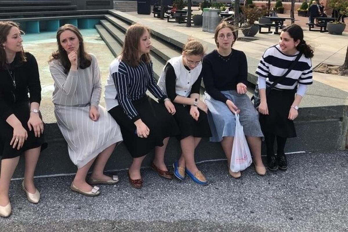 a group of women sitting on a bench