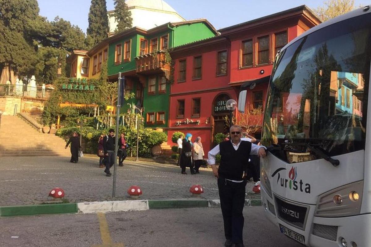un bărbat stă în fața unui autobuz