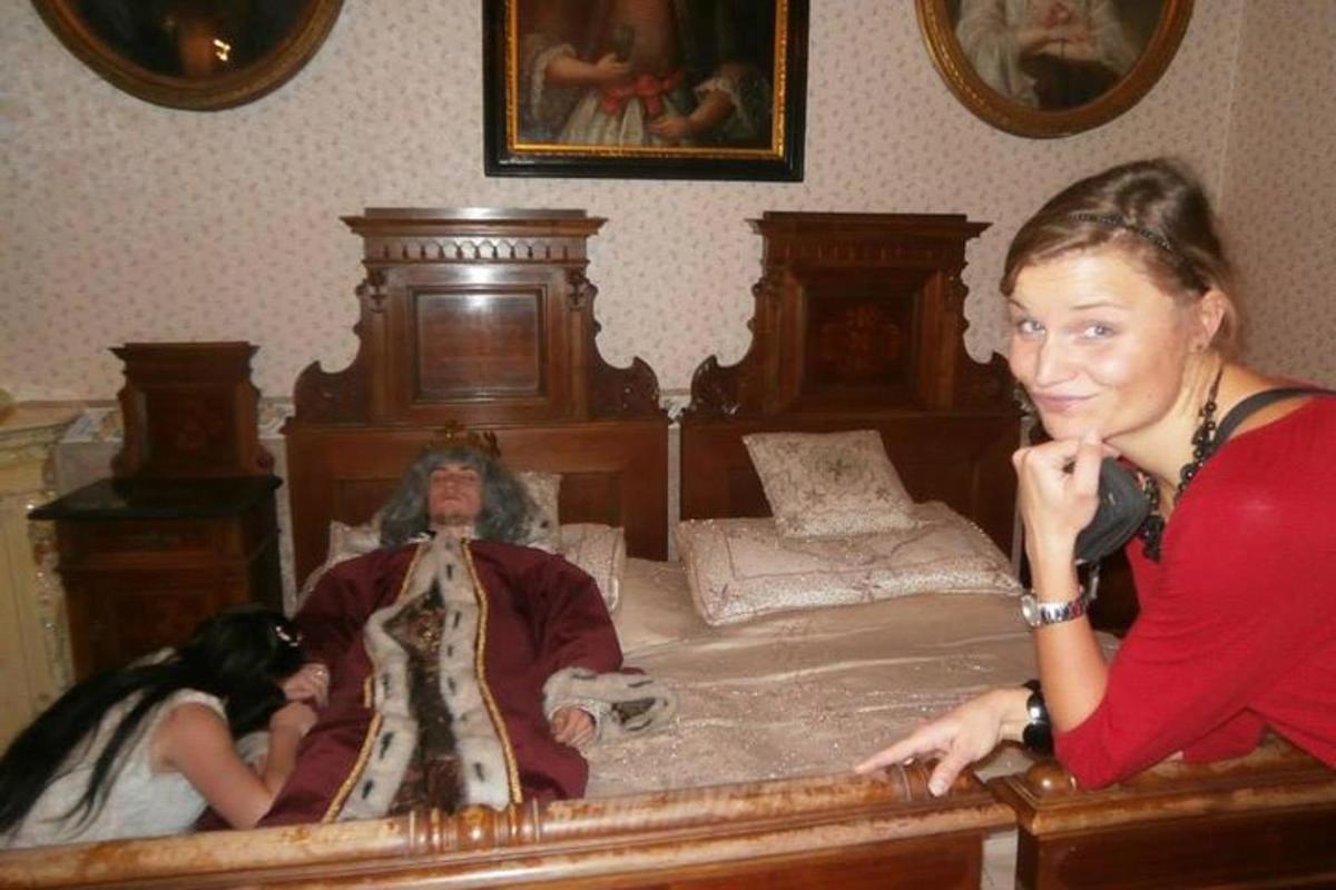 una donna in piedi davanti a un letto con un uomo