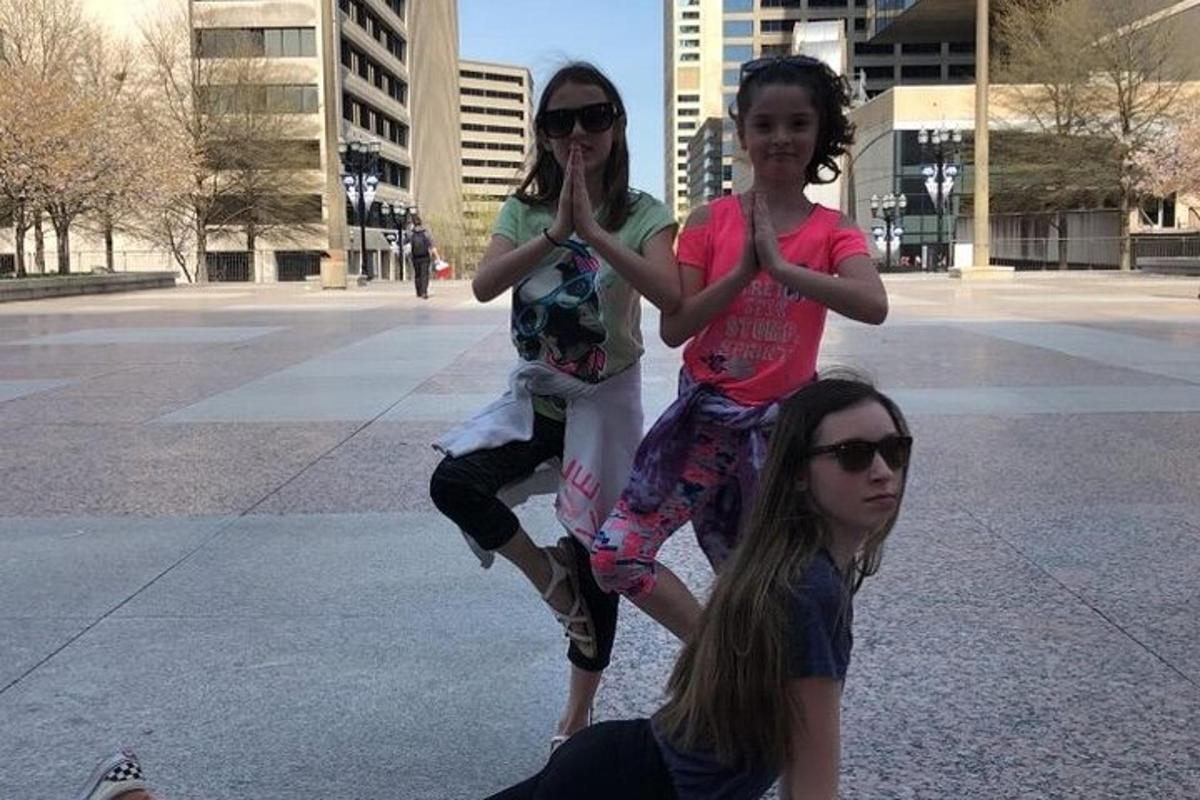 a group of three girls dancing on a sidewalk
