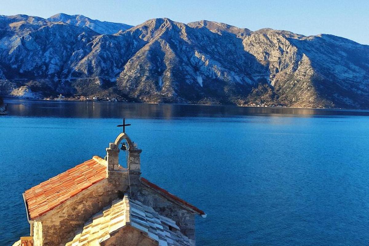 a church with a cross on top of a body of water