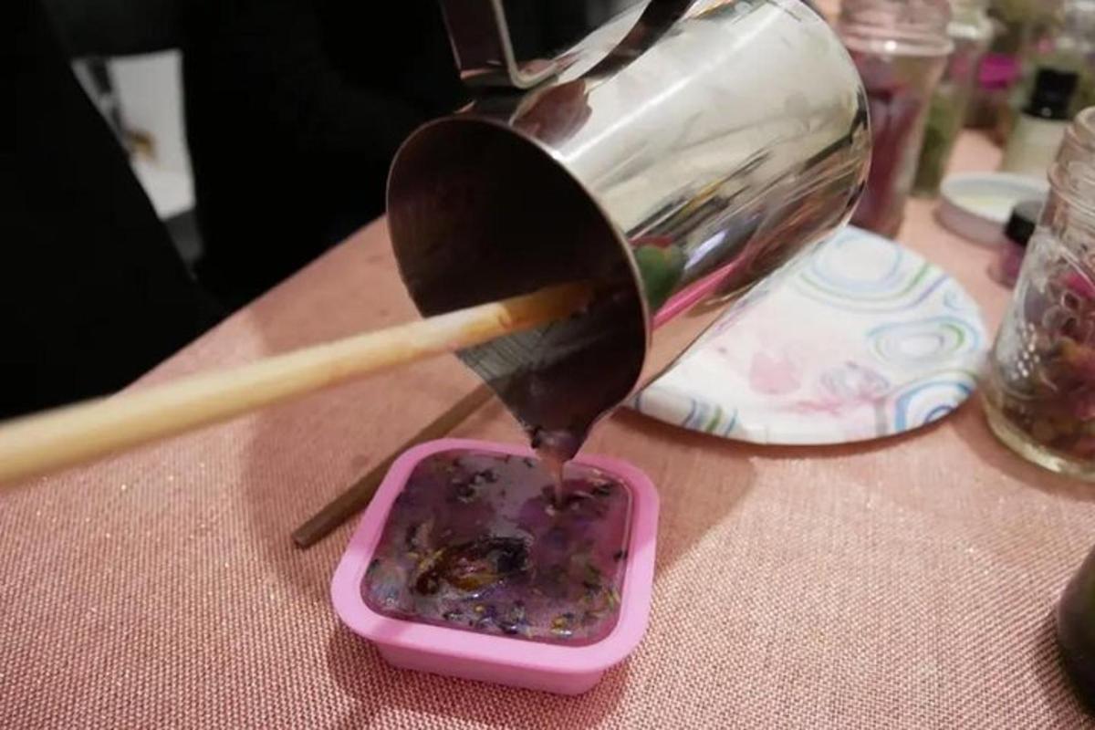 a person is holding a wooden spoon in a container