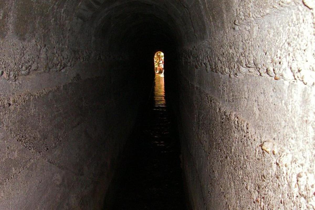 a dark tunnel with a boat in the end of it