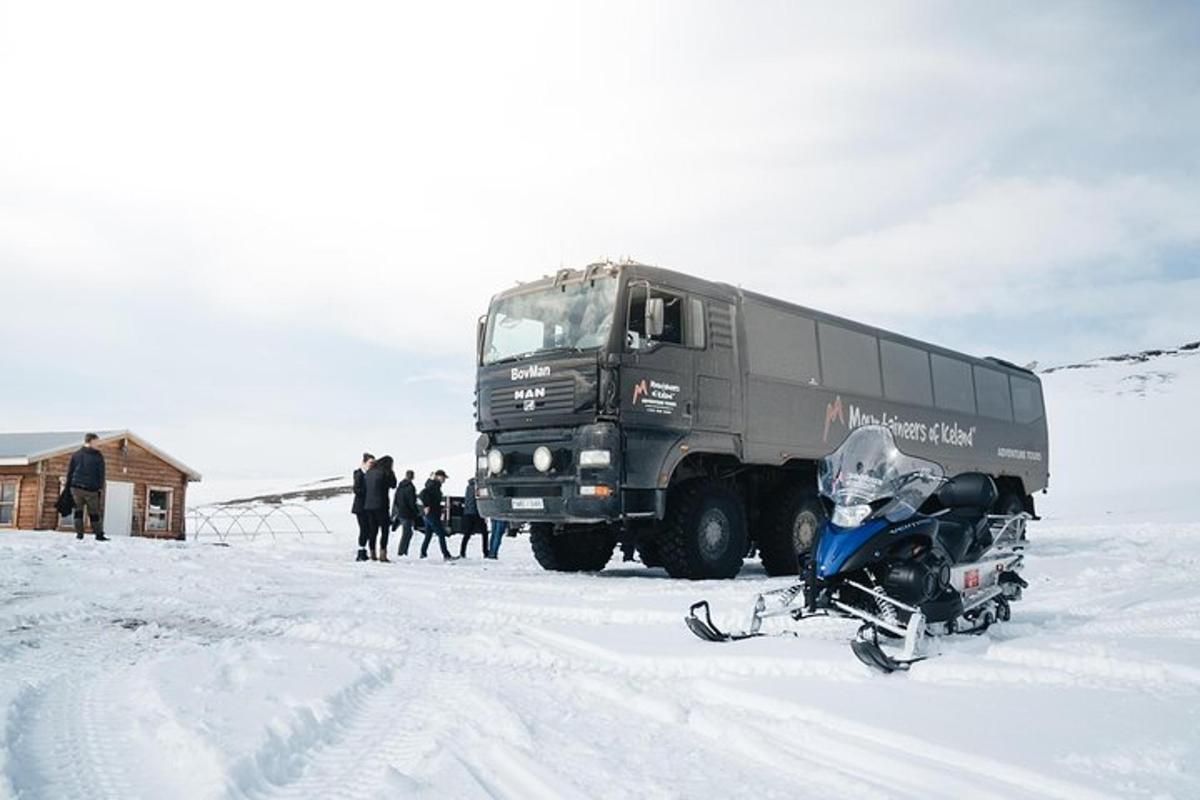 um caminhão estacionado ao lado de uma motocicleta na neve