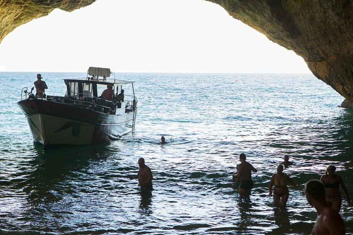 eine Gruppe von Menschen steht im Wasser in der Nähe eines Bootes