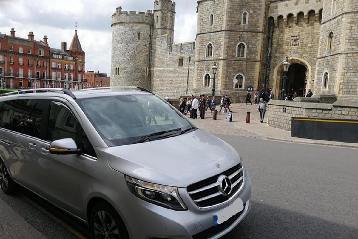 a silver car parked in front of a castle