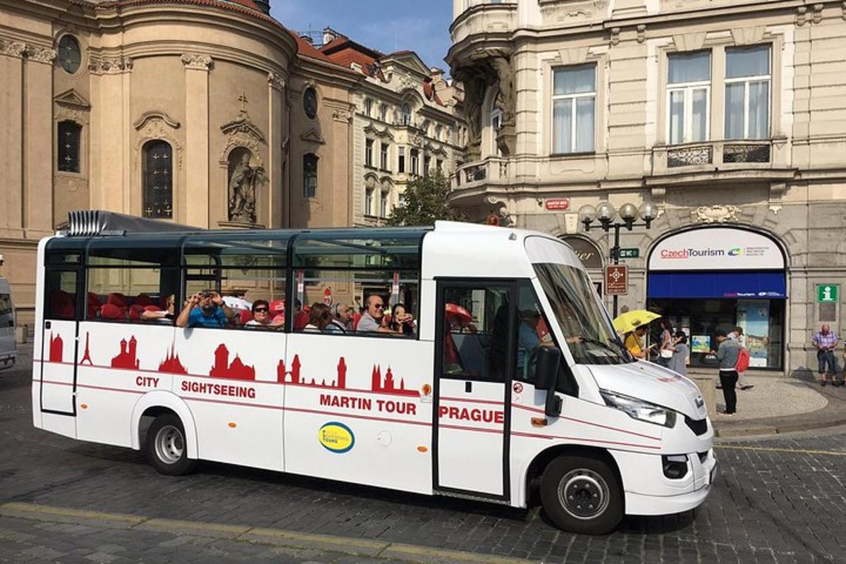 a white bus driving down a street with people inside