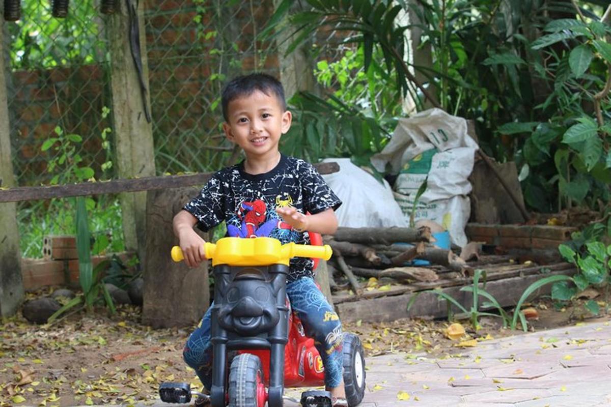 một cậu bé đang lái một chiếc xe máy đồ chơi