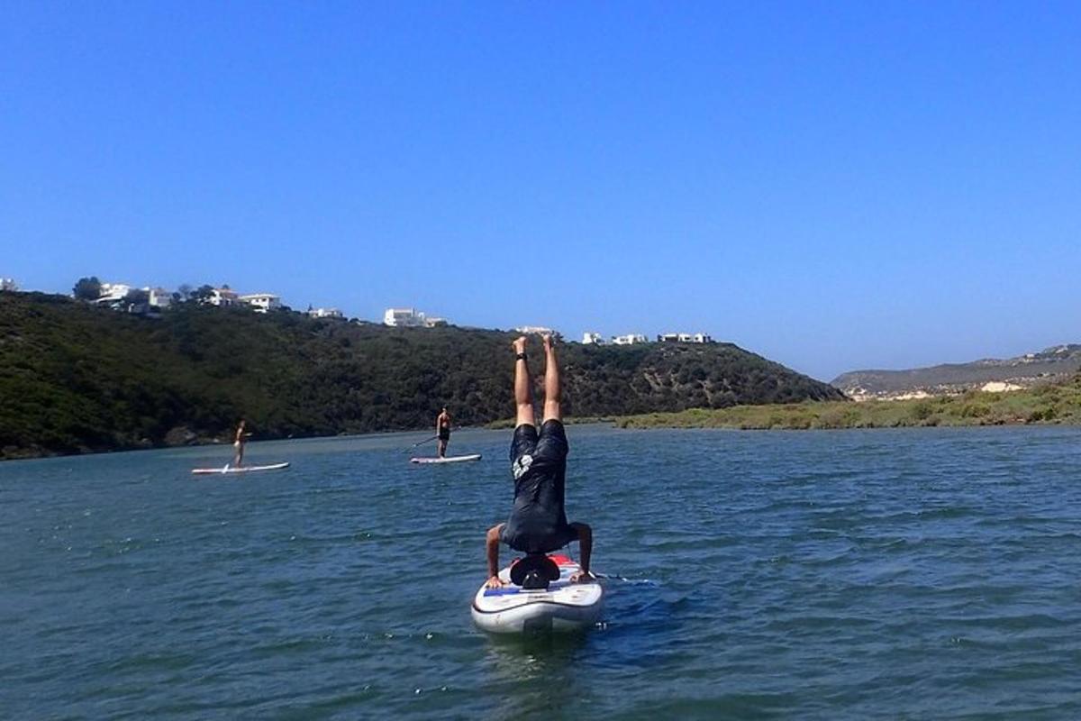 osoba dělá stojku na rukou na raftu ve vodě