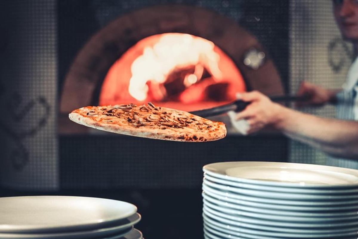 pizza na talíři před pecí na pizzu