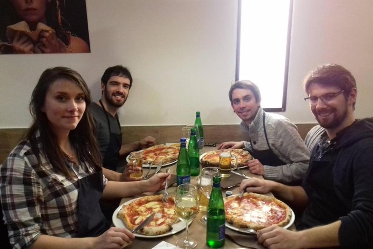 Un grupo de personas sentadas alrededor de una mesa comiendo pizza