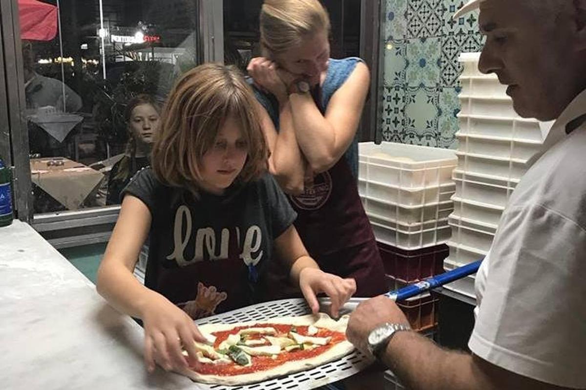 malá holčička sedící před pizzou
