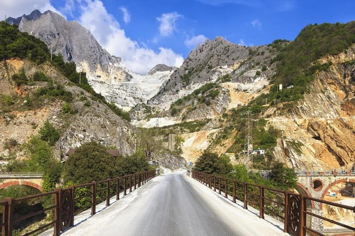 an empty road in a mountain range with a bridge