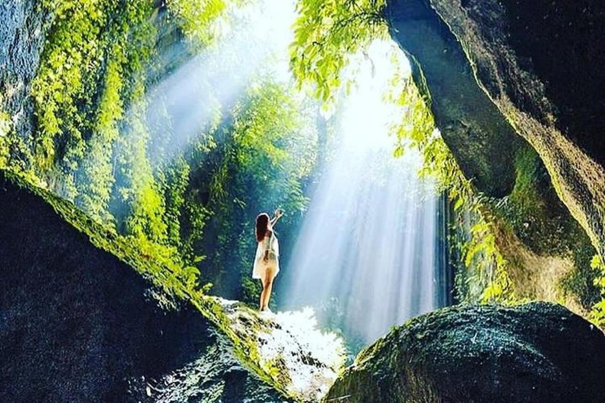 o femeie care stă în fața unei cascade