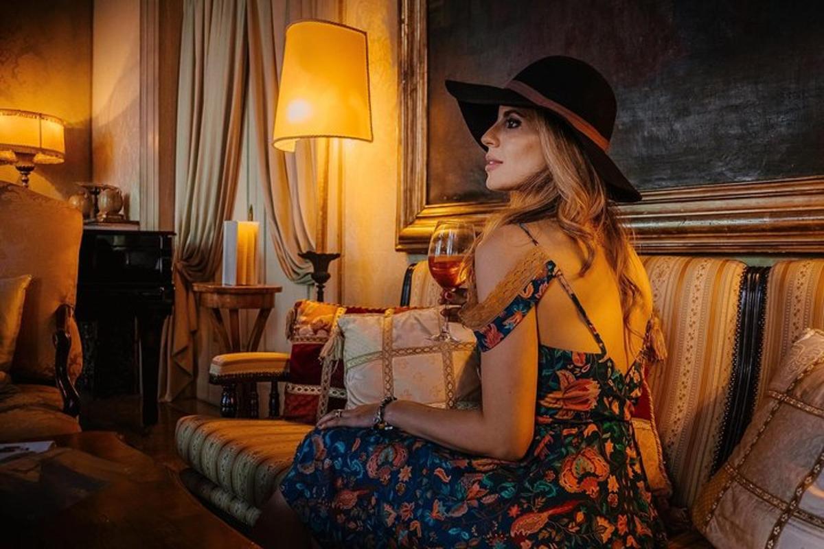 una donna seduta su un divano con in mano un bicchiere di vino