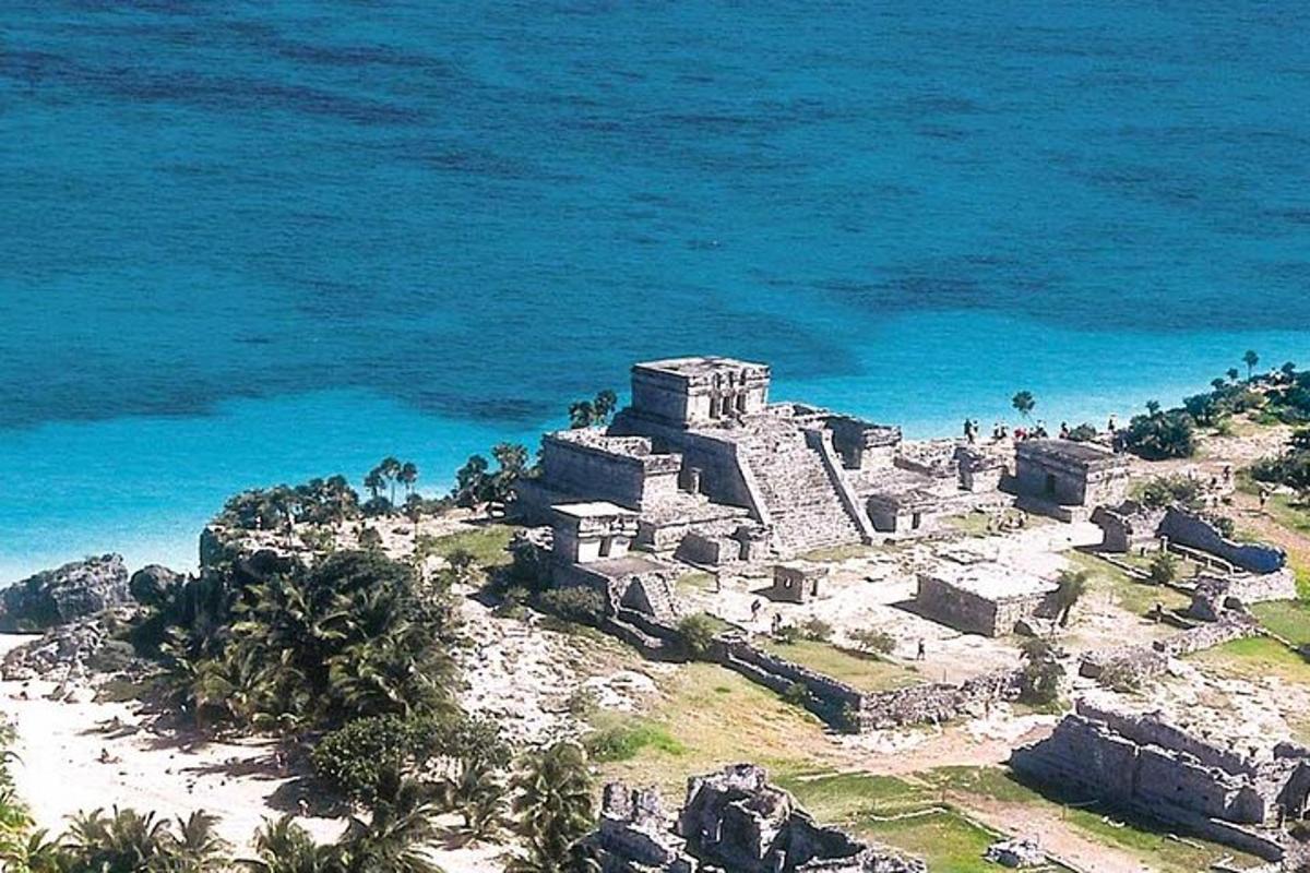 an old building on a hill next to the ocean
