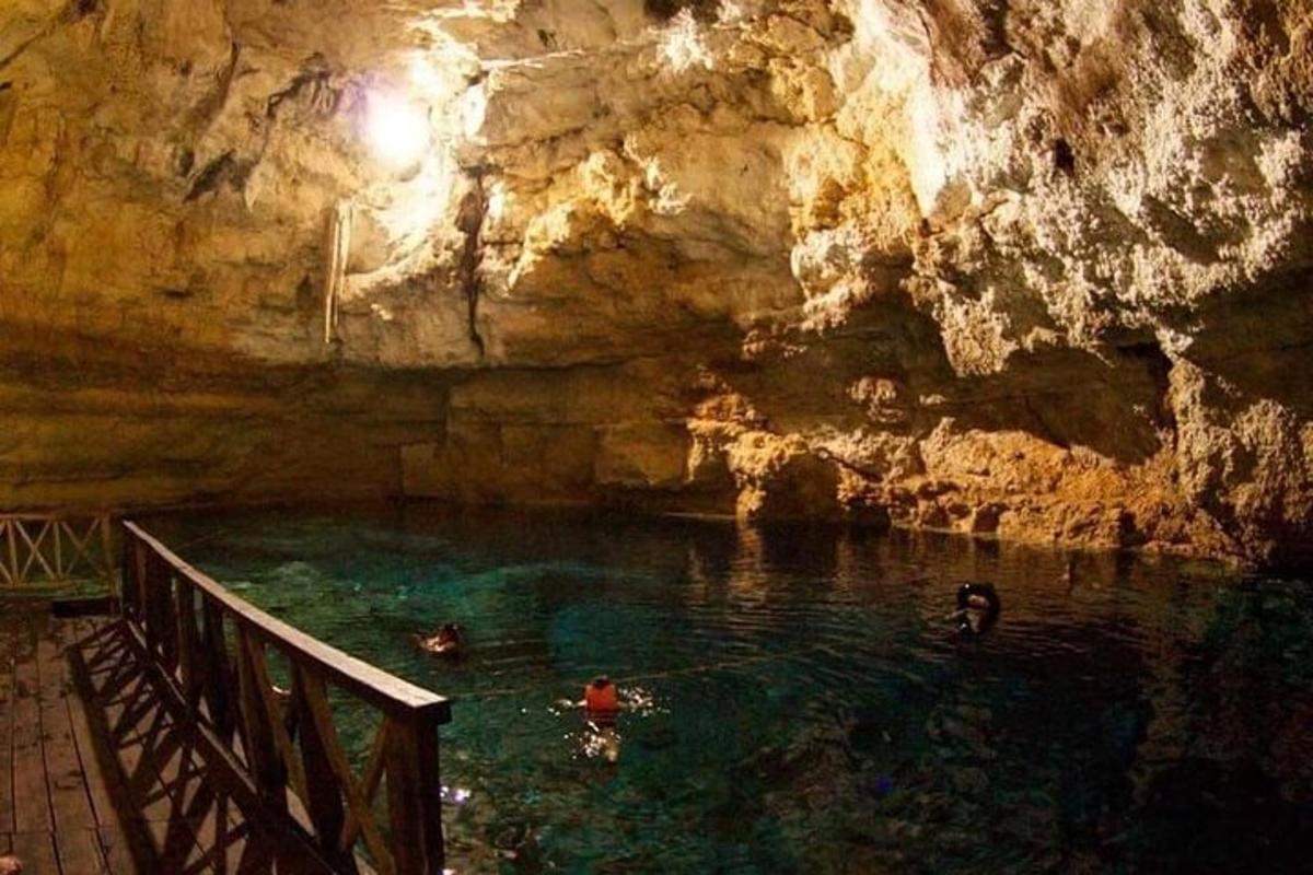 people swimming in a pool in a cave