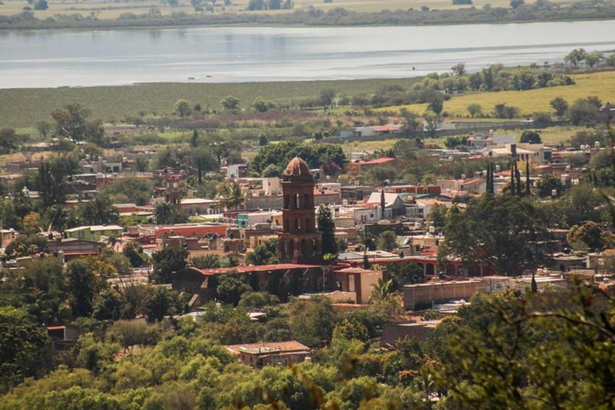 a small town with a clock tower and a lake