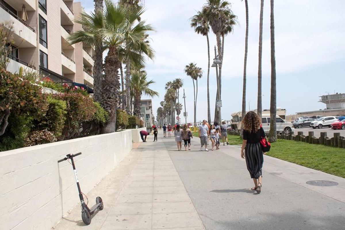 a woman walking down a sidewalk next to a scooter
