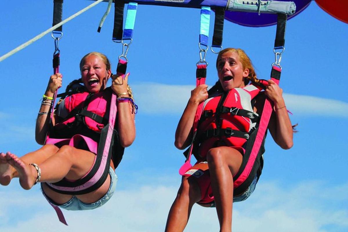 two women in life jackets are riding on a zip line