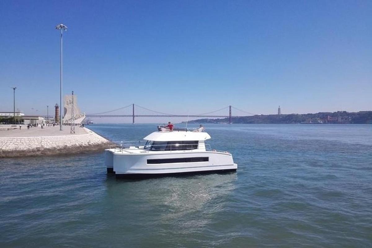 um barco branco na água com uma ponte ao fundo