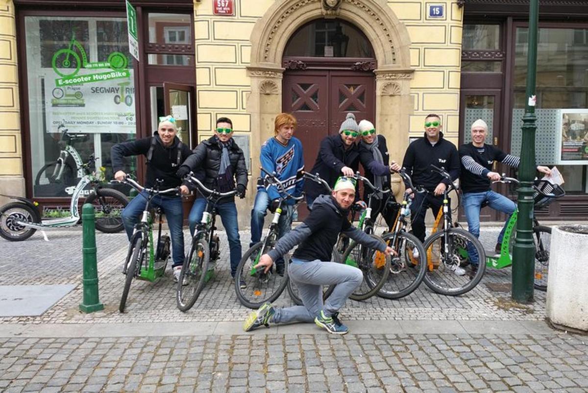 Un grupo de personas en bicicleta frente a un edificio.