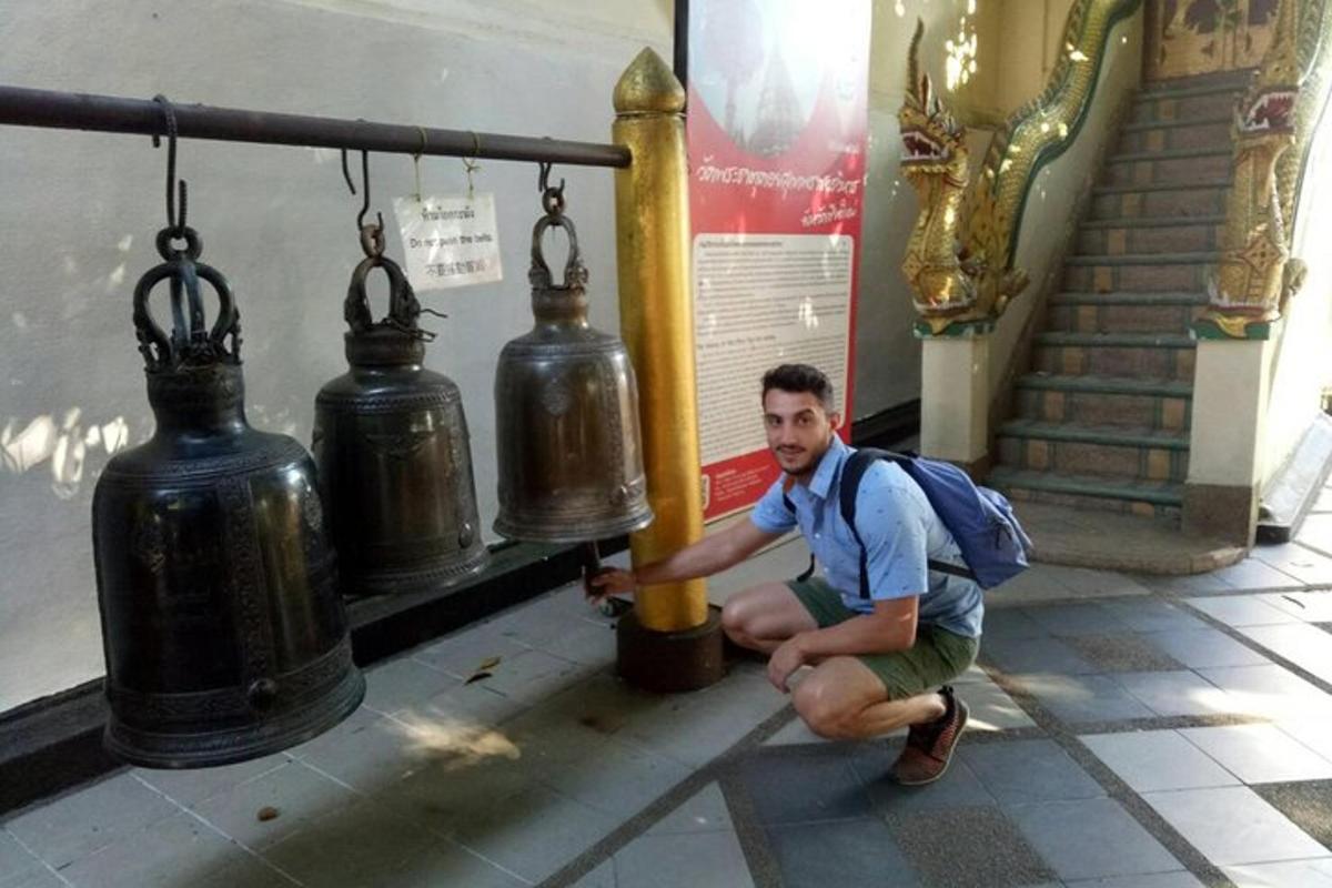 Muž s batohem dřepí vedle požárního hydrantu