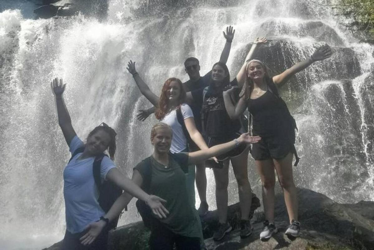 grupa ljudi stoji ispred vodopada
