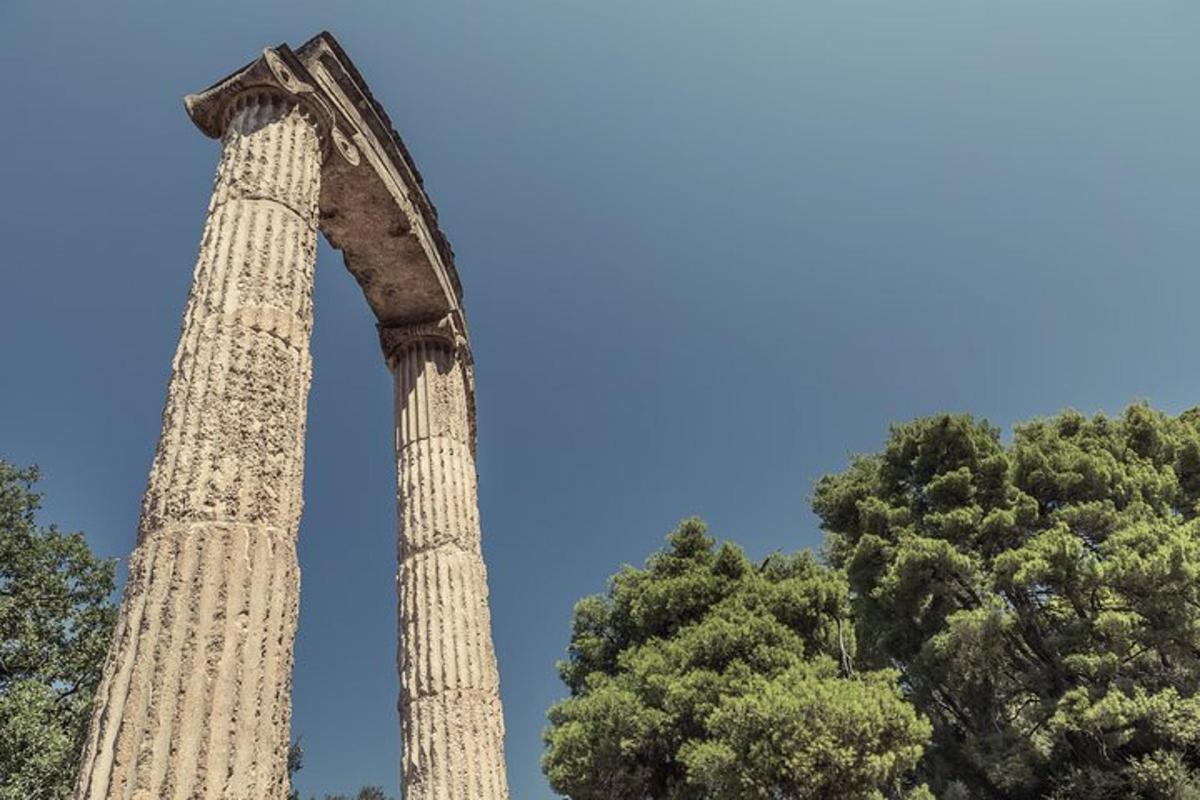 μια αψίδα με δύο κίονες μπροστά από δύο δέντρα