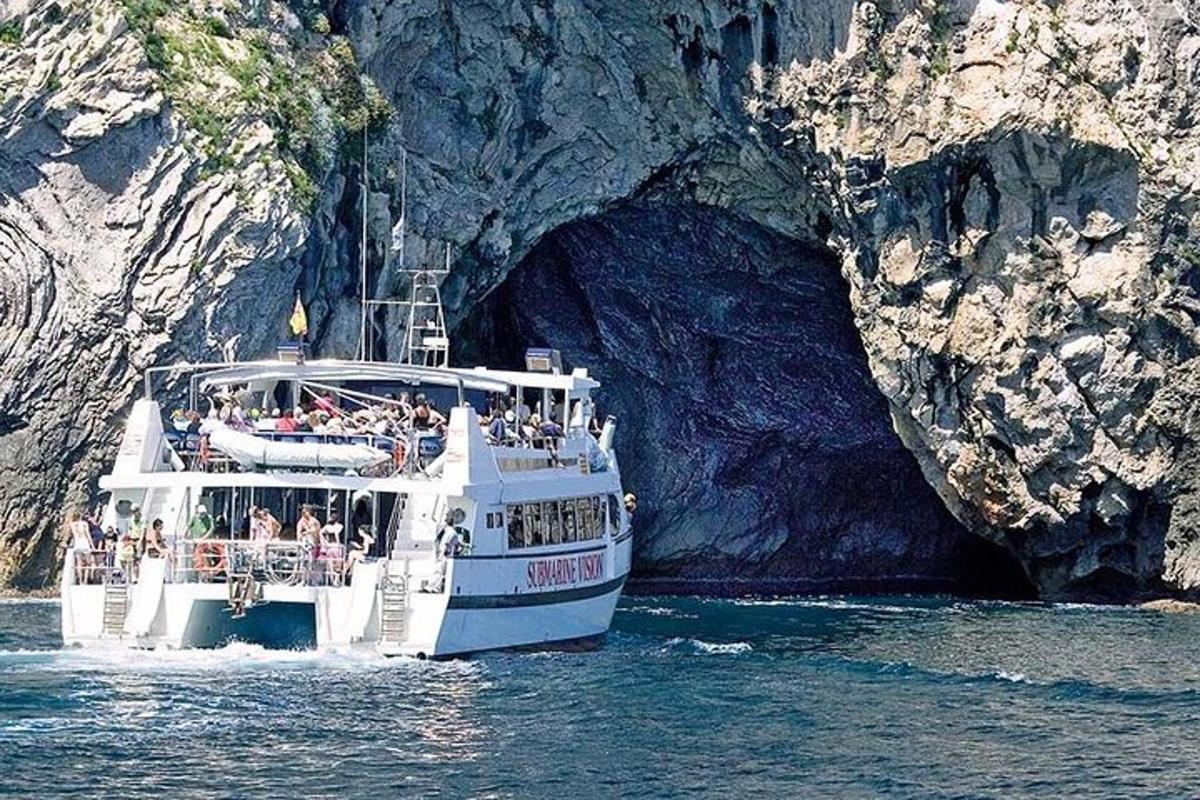 una barca blanca a l'aigua prop d'una cova
