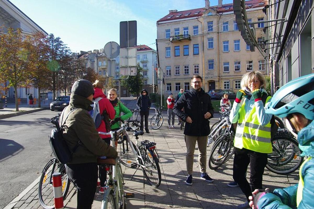 a group of people standing on a sidewalk with bikes