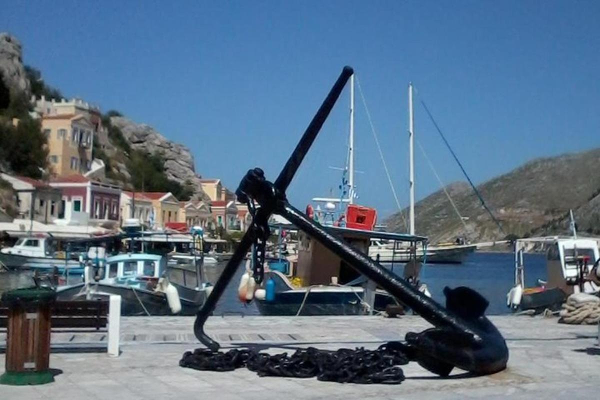 Una estatua de un cangrejo en un muelle con barcos.