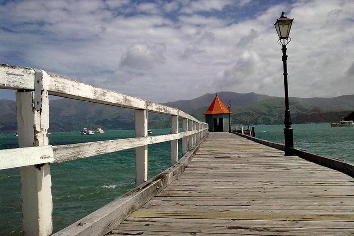 a wooden pier with a street light on the water