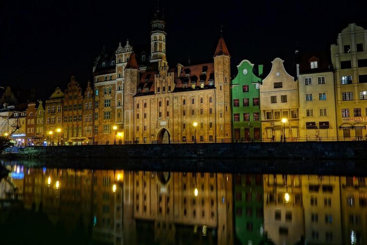 a group of buildings in front of a river at night